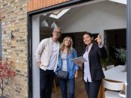 Real estate agent showing a house for sale to a couple